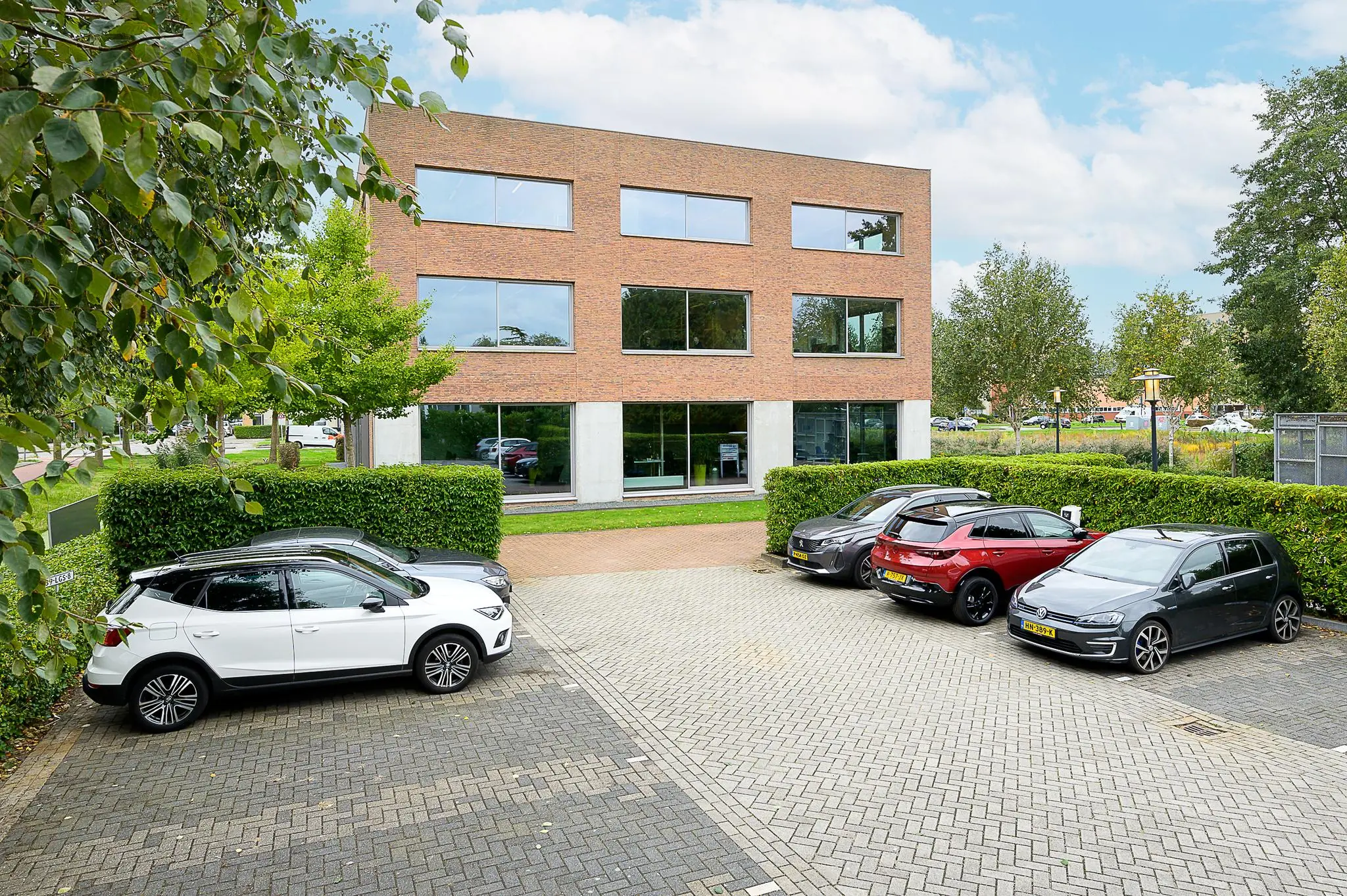 Zakelijk kantoorpand aan de Jacques Dutilhweg met geparkeerde auto’s op de voorgrond.
